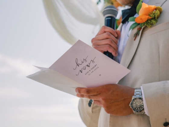 A groom reading vows at a wedding ceremony.