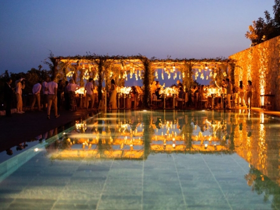 A vibrant outdoor dining scene by the pool at dusk.