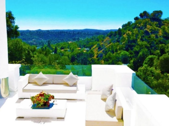 Stylish patio with plush seating and lush landscape.