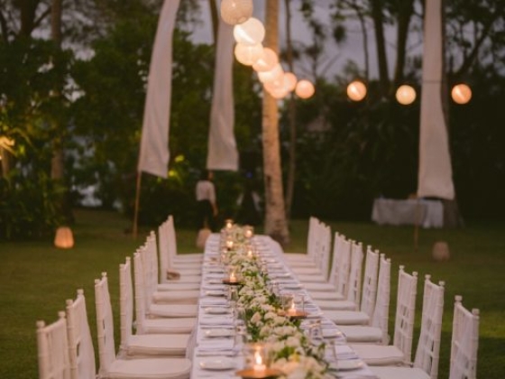 A beautifully arranged long table in a garden at dusk.