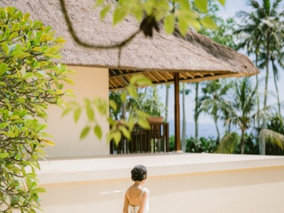 A bride in a flowing dress near a serene location.