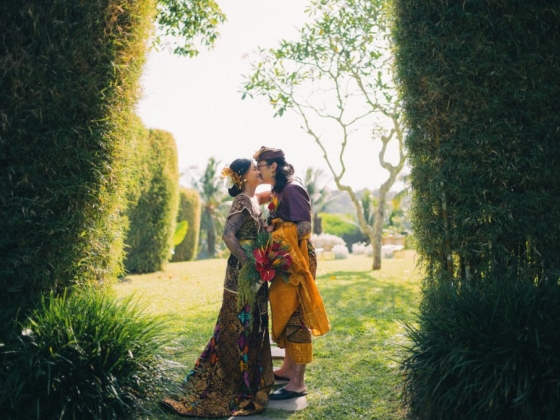 A romantic moment between two people in a lush setting.