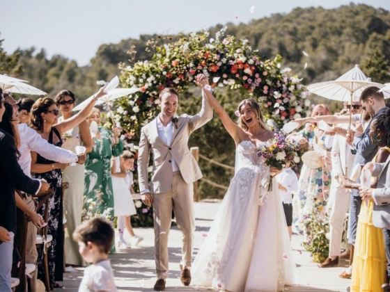 A joyful couple exits their wedding, surrounded by friends and family.