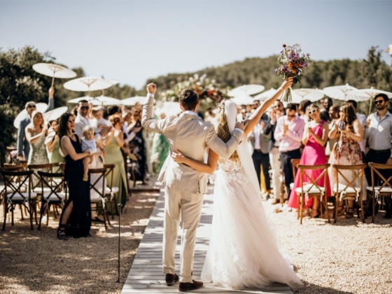 A joyful wedding moment with happy guests applauding.