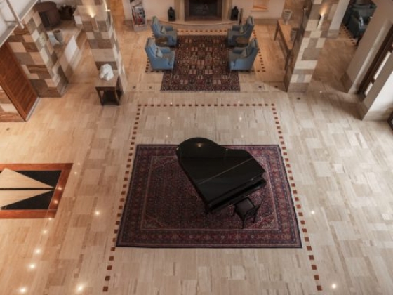 Spacious lobby featuring a grand piano and cozy chairs.