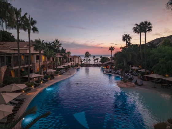 Serene pool area at a resort with ocean view at dusk