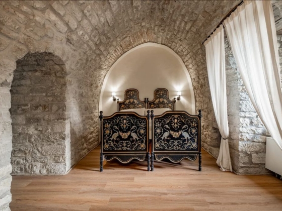 Cozy room featuring vintage beds in a stone setting.