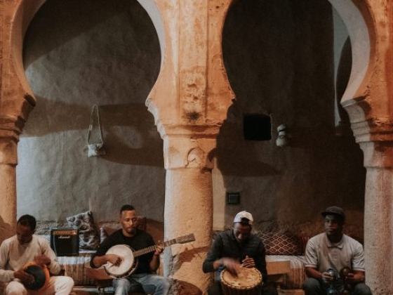 A group of musicians perform together in an ornate room.