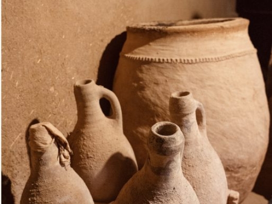 A collection of clay pots and jars on a wooden stand.