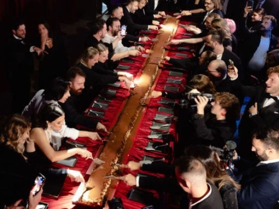 Guests engaged in a glamorous dinner setting.