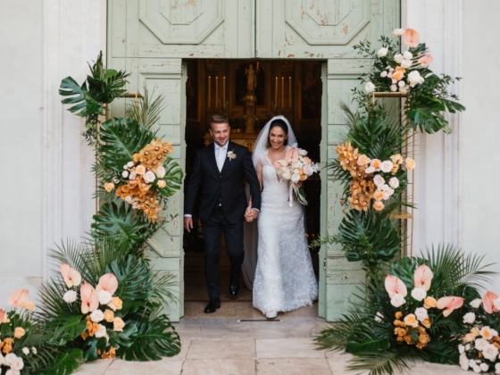 Couple joyfully leaves the wedding venue together.