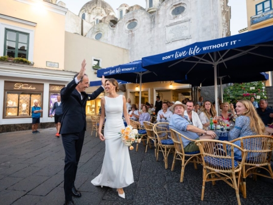 Couple joyfully dances amidst guests at a wedding celebration.