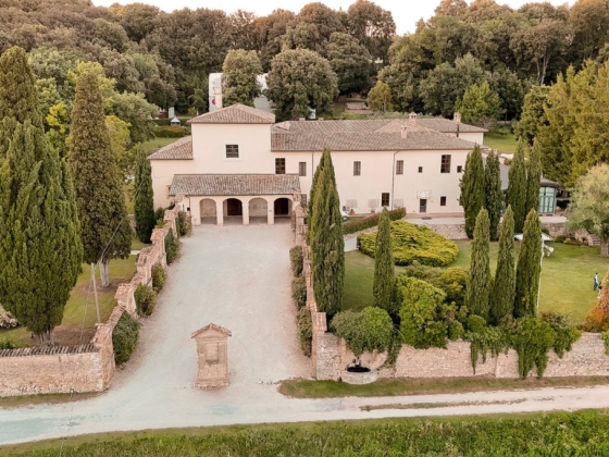 A spacious villa with a gravel driveway and lush greenery.