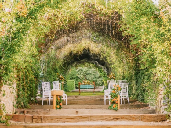 Charming garden space with chairs and floral decorations for a wedding.