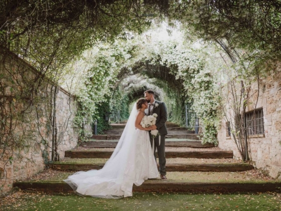 A couple shares a romantic moment in a lush garden.