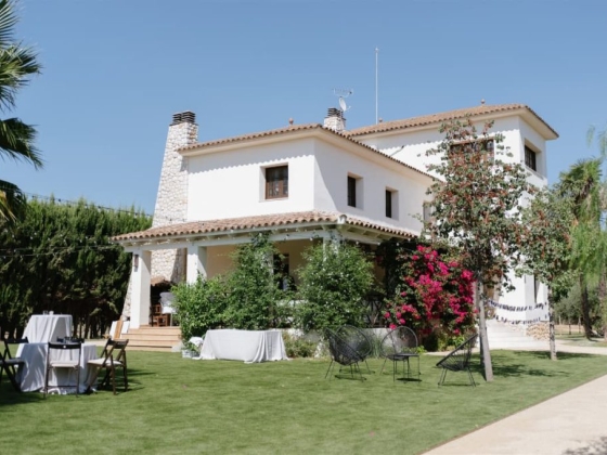 A sunny view of a charming house with gardens.