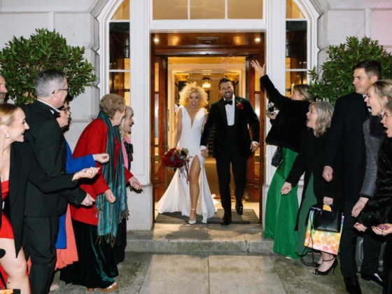 A happy couple celebrated by guests after a wedding.