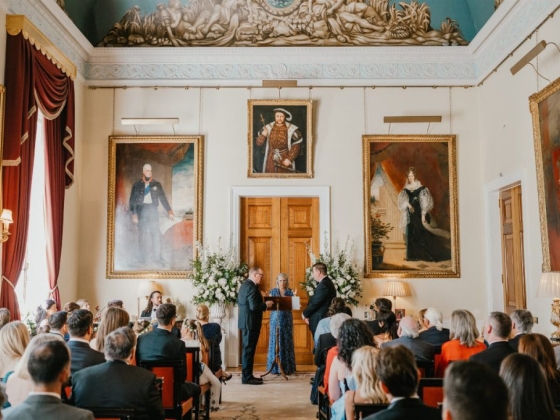 Couple exchanging vows in a grand setting.
