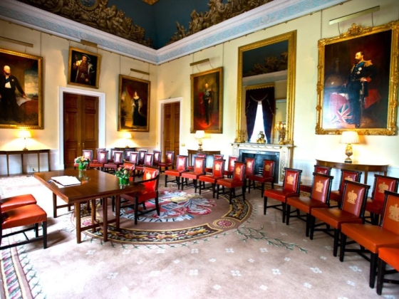 Interior space featuring historic portraits and seating arrangements.