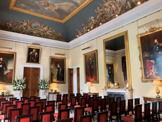 A grand hall featuring portraits and decorative seating