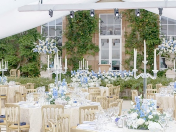 Stylish tables set for a wedding under a tent.