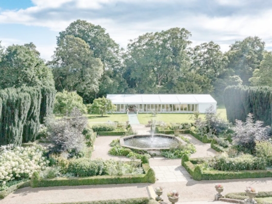 A serene garden scene featuring lush greenery and a central fountain.