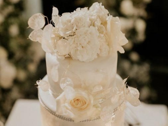 white wedding cake with flowers and green