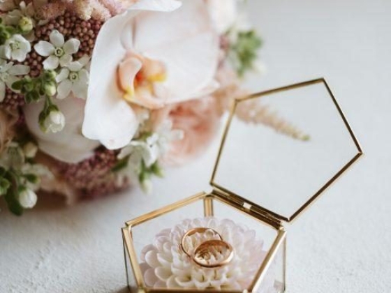 golden glass wedding rings with rose bouquet