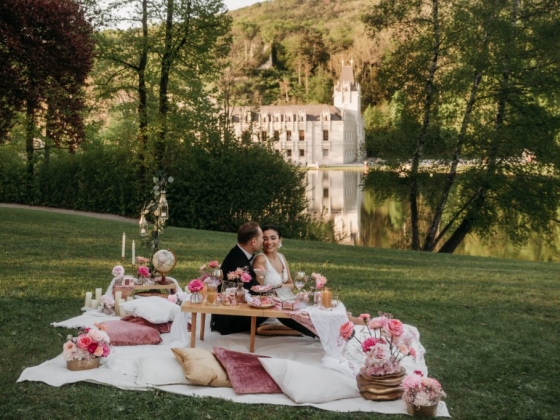 A romantic picnic scene featuring a couple amidst beautiful scenery.