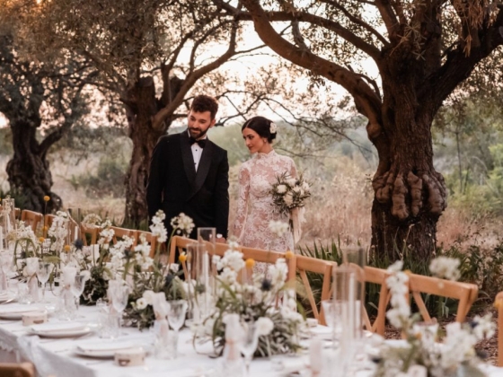 A bride and groom walk together amidst elegant wedding decor.