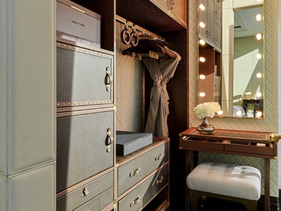 Stylish closet featuring drawers and a vanity mirror.