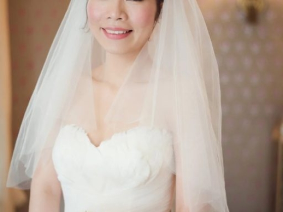 A bride posed elegantly in bridal attire with flowers.