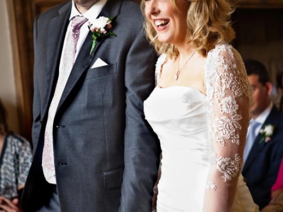 Happy couple holding hands at their wedding ceremony.