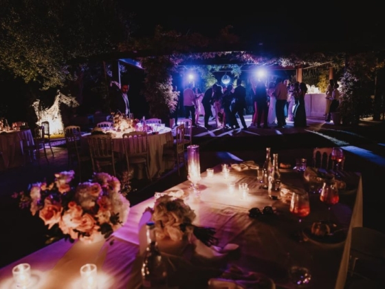 A vibrant outdoor celebration with dancing and candlelight.