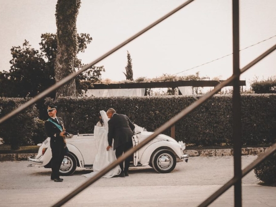 A couple arrives at their wedding in a classic car.