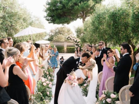 A joyful wedding celebration with guests applauding.