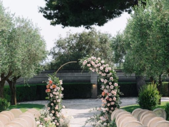 An elegant floral archway leads down the aisle.