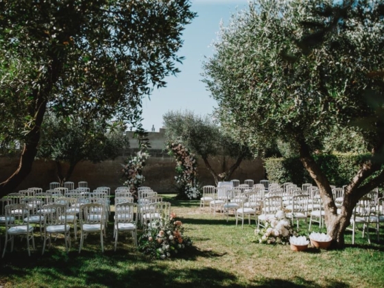 Charming garden wedding with rows of white chairs.