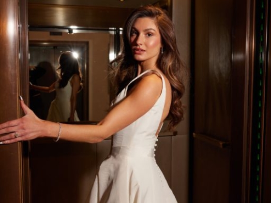 A woman poses gracefully in a stylish elevator.