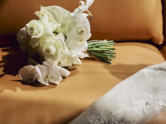 A beautiful bridal bouquet resting on a leather sofa.