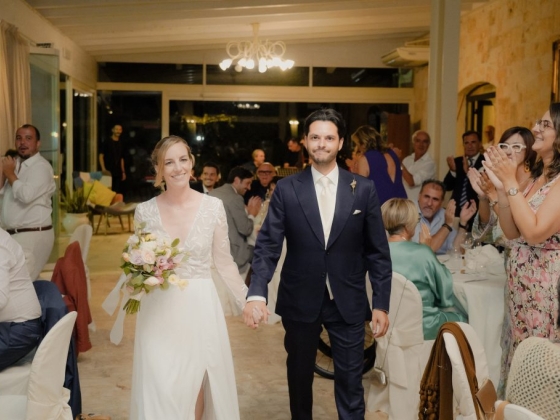 Newlyweds are greeted with applause at their wedding celebration