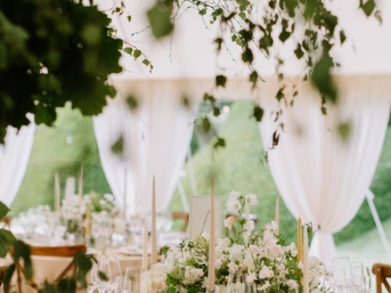 Beautifully arranged table under a tent with greenery.