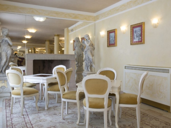 Charming dining space featuring white furniture and statues.