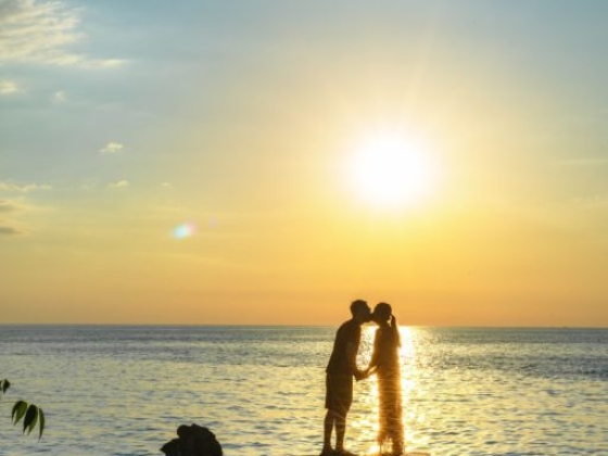 Romantic moment on a serene beach at sunset.