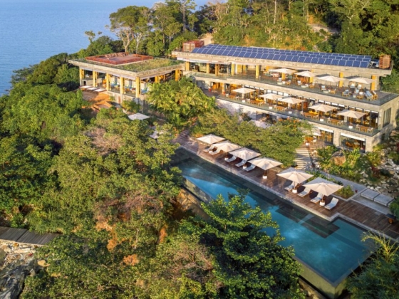 A stunning resort nestled in lush greenery by the sea.