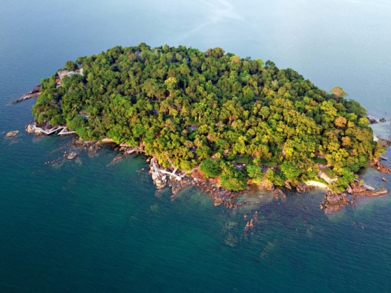 Serene island oasis with dense vegetation and rocky shores.