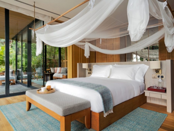 A serene bedroom featuring a canopy bed and natural light.