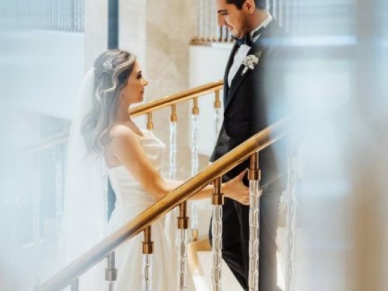 A couple gazes at each other on a beautiful staircase.