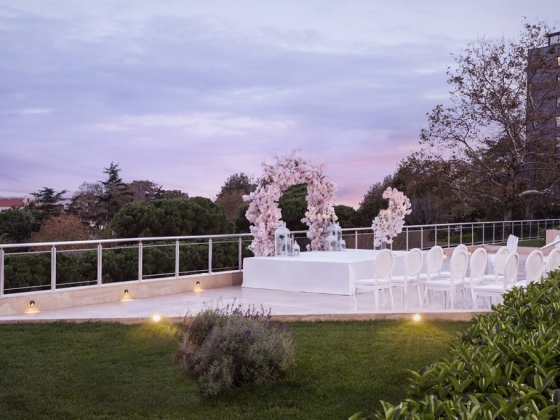 Elegant ceremony space with white chairs and flowers.