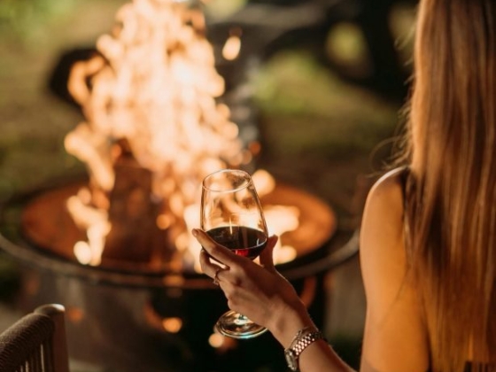 Enjoying a cozy evening by the fire with wine.